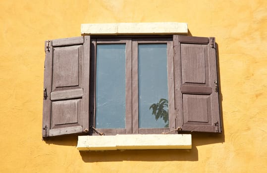 Artistic old opened wood windows outside the building among the sunlight.