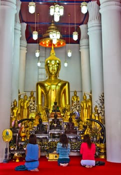 Three Ladies at Buddha Church in front of Buddha Image and servants .