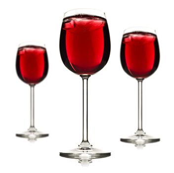 Three wine glasses with red fruit juice and ice on a white background