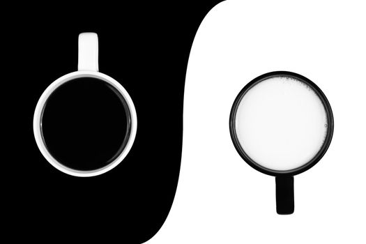 A white cup of black coffe on black background and a black cup of white milk on a white background, separated by a curved border