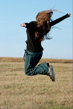 Jumping young girl with long hair in the air