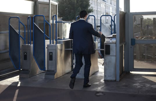 The man passes through a turnstile in the underground. Paris, France