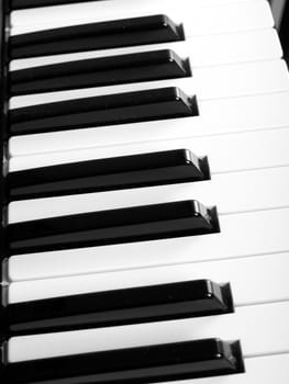 Detail of black and white keys on music keyboard - over black background