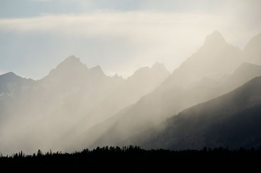 Rays of light breaking through storm clouds above the Teton Mountains, Grand Teton National Park, Wyoming, USA