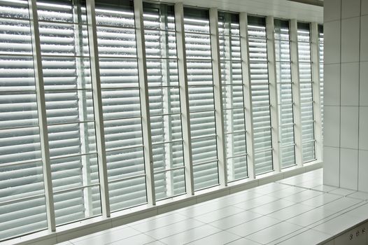 Contrast window panels with blinds beside tiled pathway