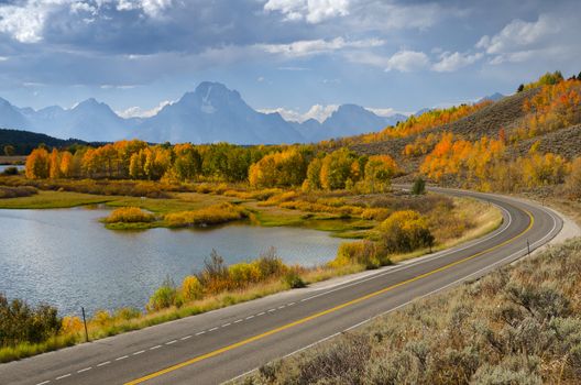 Scenic highway, autumn aspens (Populus tremuloides) and the Teton Mountains, Grand Teton National Park, Wyoming, USA