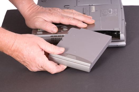 technician Installing a new battery in a laptop computer