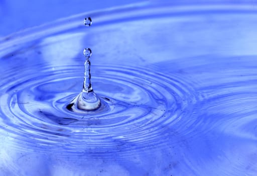 Water drops hitting the surface of a pool and creating unique abstract forms