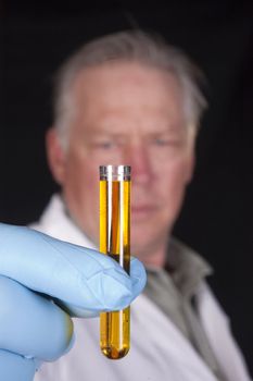 chemical engineer, doctor or research scientist using a pipette to take a sample of a chemical from a test tube