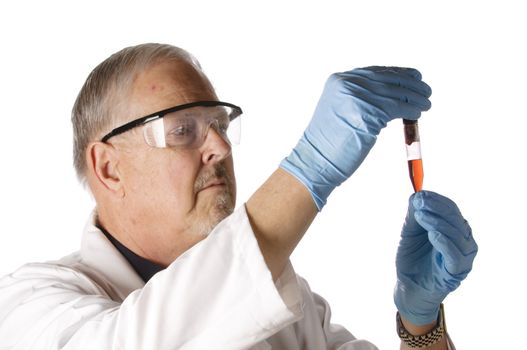 Dramatic lighting of an older doctor looking at a plasma vial for analysis