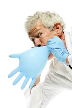 older Doctor blowing up a glove to amuse so that the tension is relived for the patient