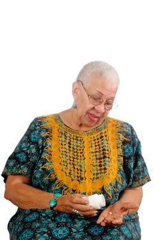 Elderly African American woman pouring her pills from a container into her hand