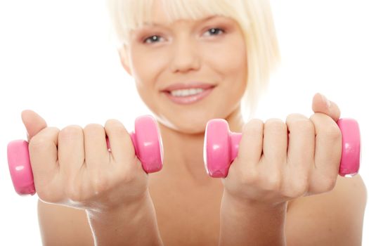 Young topless woman exercising with dumb bells