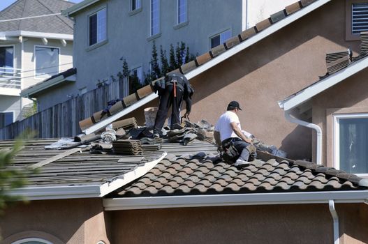 Hispanic roofer laying roofing tile