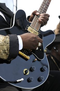 african american male lead guitarist playing in live concert