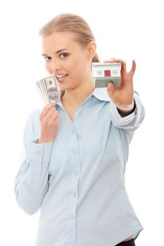 Young beautiful business woman with house model and dollars in hands, isolated on white background