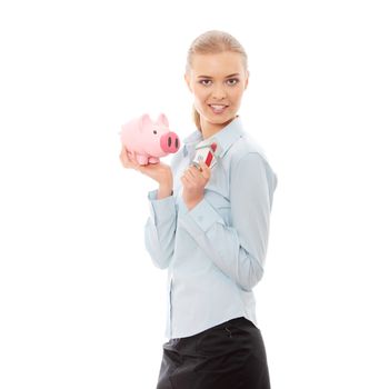 Young beautiful business woman with house model and piggy bank in hands, isolated on white background