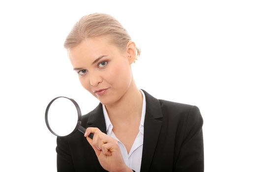 Young attractive smiling business woman looking into a magnifying glass, isolated on white background