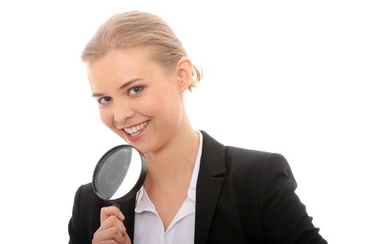 Young attractive smiling business woman looking into a magnifying glass, isolated on white background
