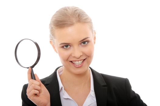 Young attractive smiling business woman looking into a magnifying glass, isolated on white background