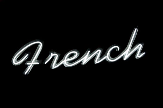 Neon sign with the word "french" over black