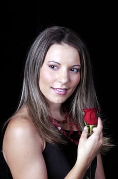 Beautiful young brunette woman holding a red rose for valentines