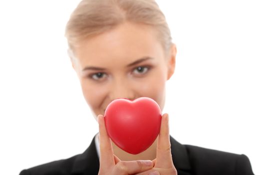 Young business woman holding heart shaped toy