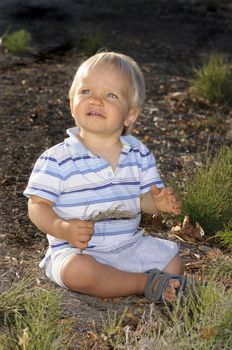 Infant playing in the autumn leaves