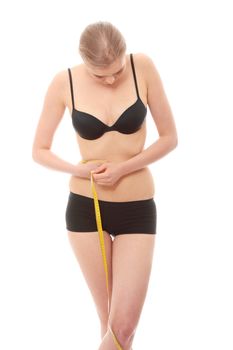 Beautiful young caucasian woman measuring her body with tape, isolated on white background