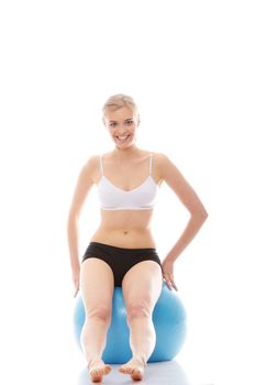 Young woman exercising with fitness ball. Isolated on white