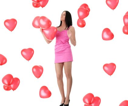 Beautiful young woman in pink elegant dress with red heart shaped balloon on a white background (love and valentines concept)