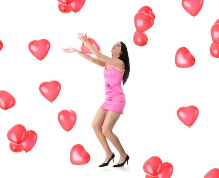 Beautiful young woman in pink elegant dress with red heart shaped balloon on a white background (love and valentines concept)