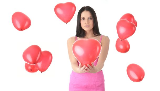 Beautiful young woman in pink elegant dress with red heart shaped balloon on a white background (love and valentines concept)