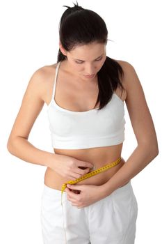 Sexy, fit, young woman measuring her waist, over white background