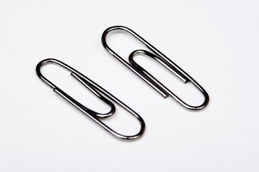 Muchos clips de metal sobre fondo blanco - A lot of metal paperclips on a white background