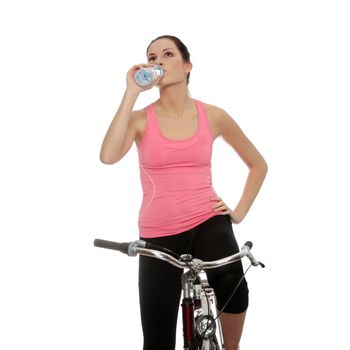 Attractive brunette woman with bike drinking water. over white background