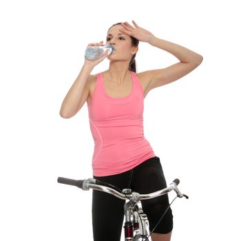 Attractive brunette woman with bike drinking water. over white background