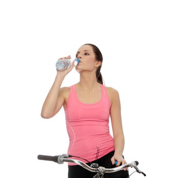 Attractive brunette woman with bike drinking water. over white background
