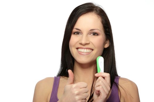 Smiling woman holding a pregnancy test, isolated on white