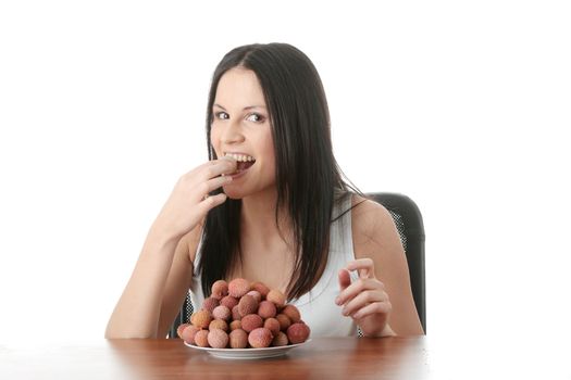 Young beautiful caucasian woman eating litchi fruits, isolated on whiet background