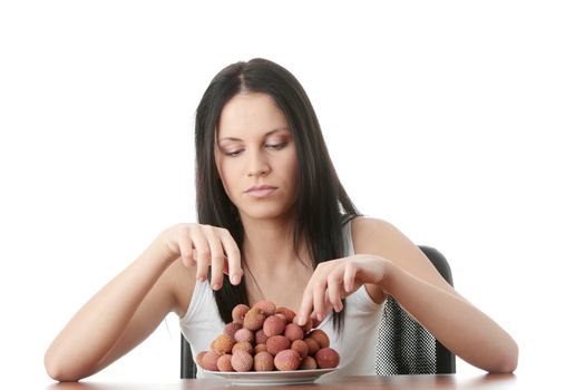 Young beautiful caucasian woman eating litchi fruits, isolated on whiet background
