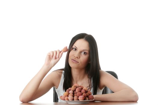 Young beautiful caucasian woman eating litchi fruits, isolated on whiet background