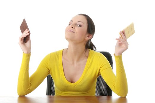 Portrait of young happy smiling woman eating dark and white chocolate