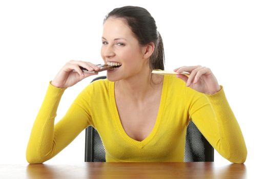 Portrait of young happy smiling woman eating dark and white chocolate