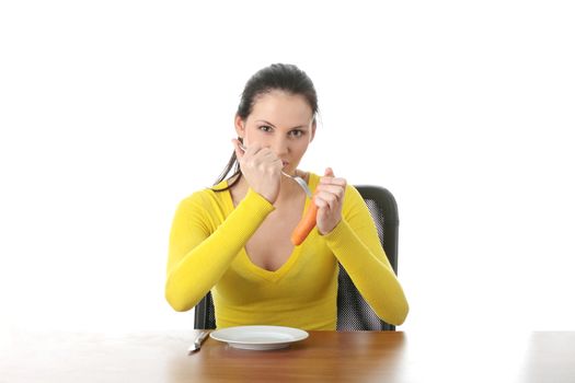 Young woman eating carrot from plate, isolated on white