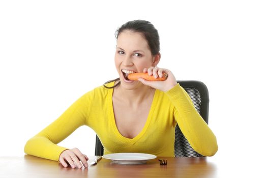 Young woman eating carrot from plate, isolated on white