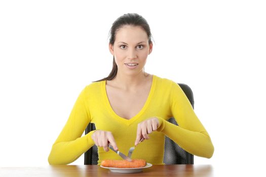 Young woman eating carrot from plate, isolated on white
