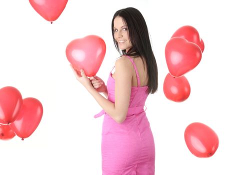 Beautiful young woman in pink elegant dress with red heart shaped balloon on a white background (love and valentines concept)