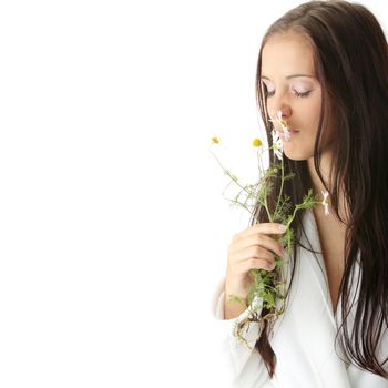 Beautiful young caucasian woman in bathrobe smeling daisy calm portrait. Isolated