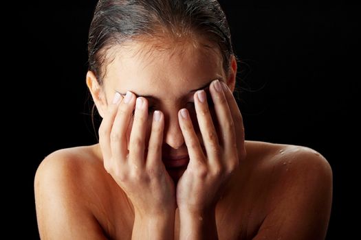Wet teen woman isolated on black background